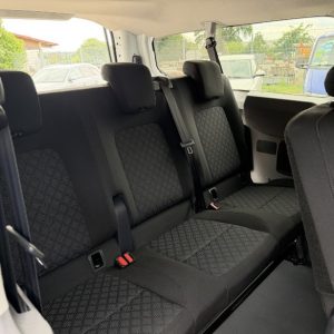 Innenraum eines Fahrzeugs mit drei Rücksitzen und Kopfstützen, Stoffbezüge mit Muster